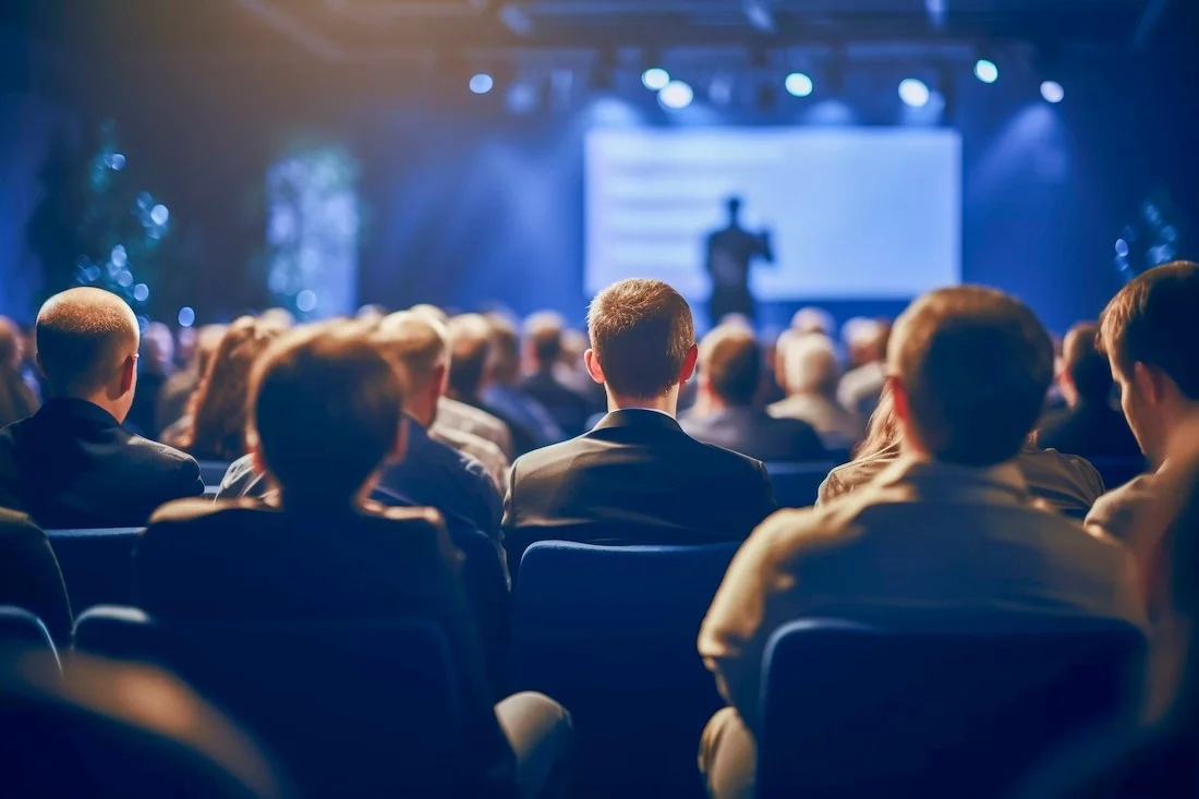 Seated audience in a large event venue hosted by Blast Marketing Agency for corporate planners in NYC